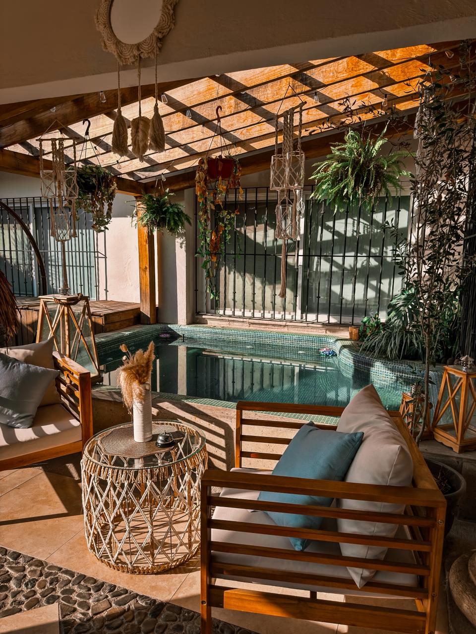 Alberca con sala lounge y pérgola de madera